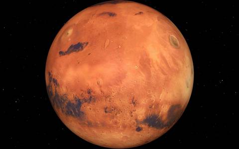 Vue de la planète Mars, montrant sa surface rougeâtre désertique et une de ses calottes polaires.
